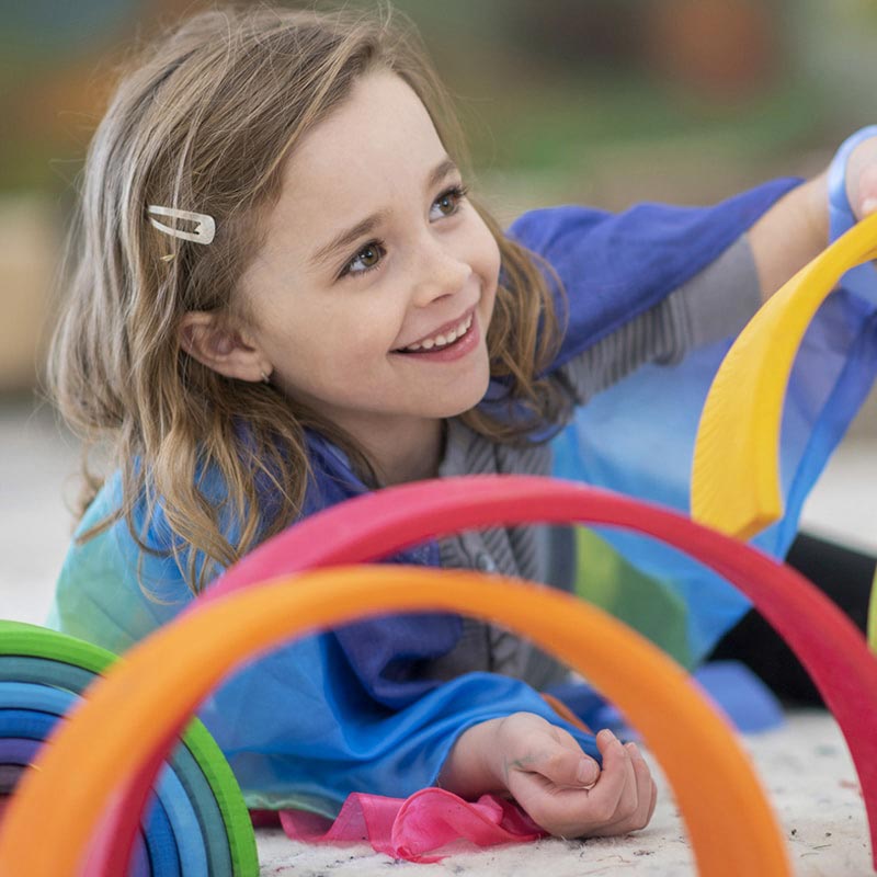 Girl playing with blocks while looking to the side