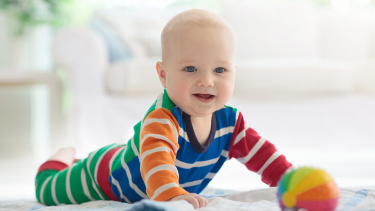 Baby boy with toys and ball