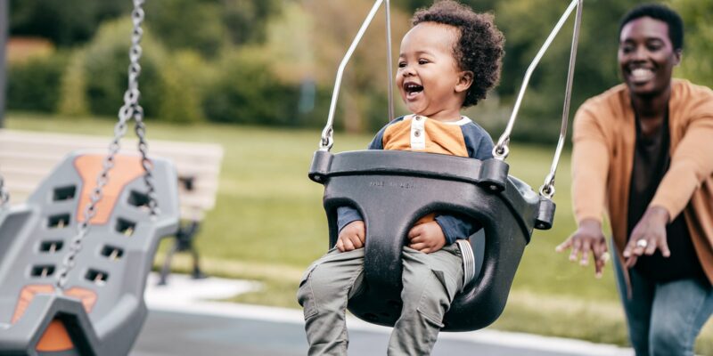 Parent pushing child on a swing