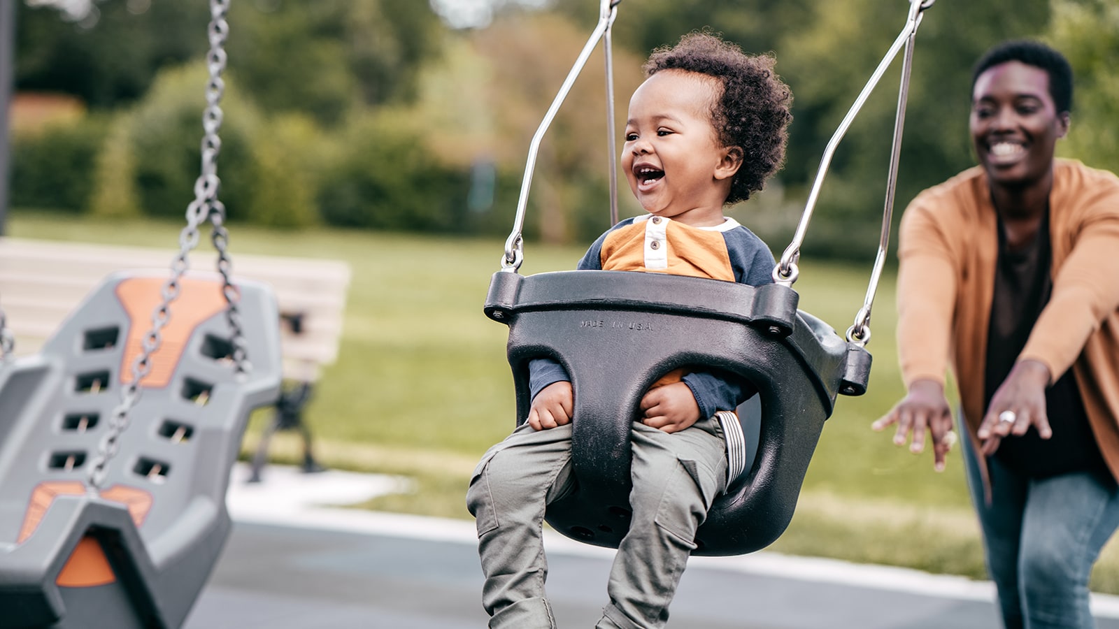 Parent pushing child on a swing