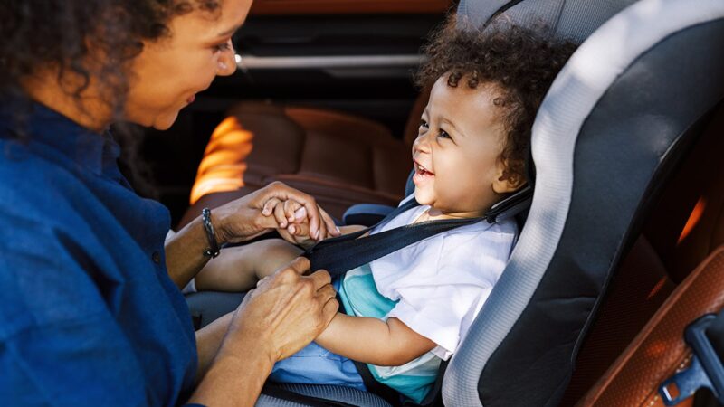 Child sitting in car seat with parent