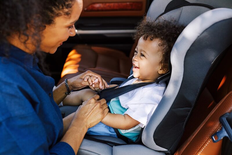 Child sitting in car seat with parent