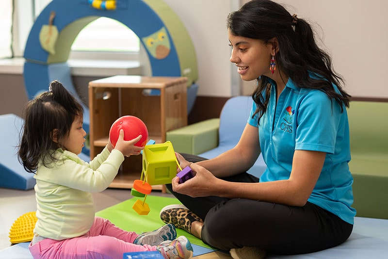 Team member and child playing